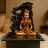 Gold statue of a seated figure with water feature on a brown background