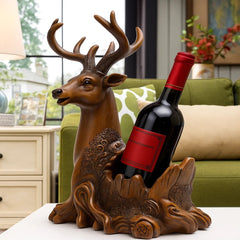 Decorative deer-shaped wine bottle holder with a red wine bottle inside, placed on a surface with a blurred background.