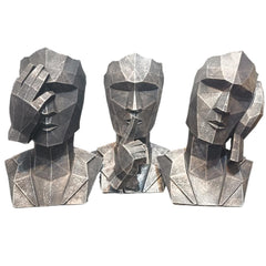 Three geometric stone sculptures of human heads on a white background